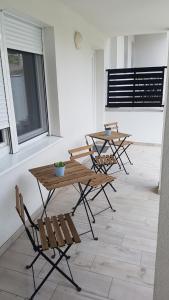 a group of tables and chairs on a patio at Domb Apartmanok in Sukoró