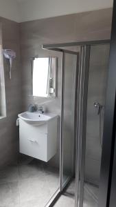 uma casa de banho com um lavatório e um chuveiro em Domb Apartmanok em Sukoró