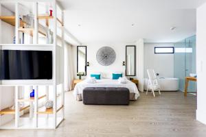 1 dormitorio con 1 cama, TV y baño en Hotel Almirante, en Alicante