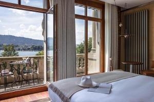 a hotel room with a balcony overlooking the ocean at La Réserve Eden au Lac Zurich in Zurich