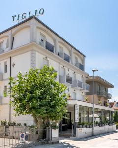 a building with a tree in front of it at Hotel Tiglio in Rimini