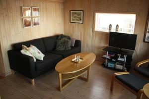 a living room with a couch and a table at Frugga Feriehus og leilighet in Straumsjøen