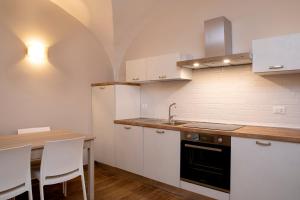 a kitchen with white cabinets and a wooden table at Residenza Cappelli - Case Vacanze in San Demetrio neʼ Vestini