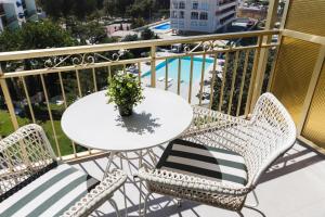 a white table and chairs on a balcony with a pool at Hotel Almirante in Alicante