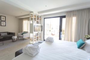 a bedroom with a large white bed and a living room at Hotel Almirante in Alicante