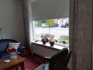 ein Wohnzimmer mit einem Fenster mit einem Sofa und einem Tisch in der Unterkunft Vakantiehuisje in Centrum Ootmarsum in Ootmarsum