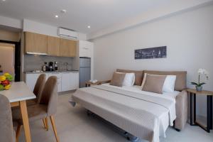 a bedroom with a large bed and a kitchen at BISALTAE SEASIDE SUITES in Keramoti