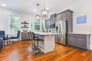 ニューオーリンズにあるSpacious 5 BR Retreat - Pool - Near It All!のバースツール付きの大きな島のあるキッチンが備わります。