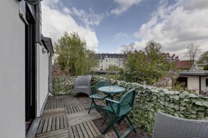 eine Terrasse mit einem Tisch und Stühlen sowie ein Gebäude in der Unterkunft Air Boardinghouse Tulip Stockum, zu Fuß - 3 Minuten zur Messe in Düsseldorf