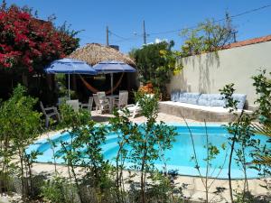 una piscina con sillas y sombrillas en un patio en Pousada Lazer do Sol, en Lucena