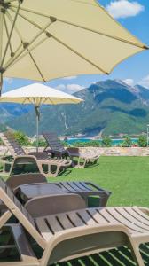 a group of lounge chairs and an umbrella at Kedros Chalet in &Aacute;yios Dhim&iacute;trios