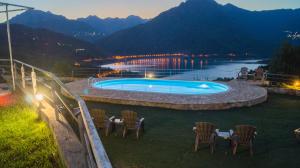 una piscina con sillas y una mesa con vistas a las montañas en Kedros Chalet, en Áyios Dhimítrios