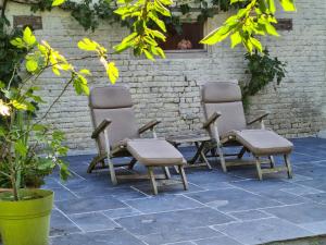 a group of three chairs sitting next to a brick wall at Biker Studio in Oudenaarde