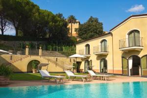 a pool with chairs and umbrellas next to a building at Villa Agnese in Sestri Levante