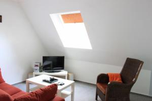 a living room with two chairs and a table and a tv at Gaestehaus-Sylvie-Wohnung-2 in List
