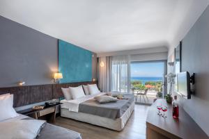 Cette chambre d'hôtel comprend un lit et offre une vue sur l'océan. dans l'établissement Club Marmara Rhodes Doreta Beach, à Theologos