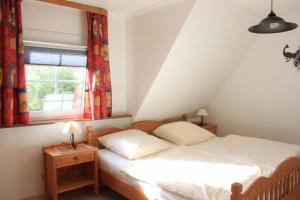a bedroom with a bed and a window at Gaestehaus-Sylvie-Wohnung-2 in List