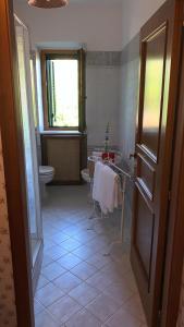 bagno con lavandino, servizi igienici e finestra di Agriturismo La CasinaRosa a Loreto Aprutino