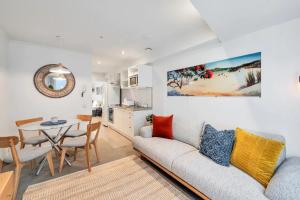 a living room with a couch and a table at Metro Living Apt near Skytower and Parking in Auckland