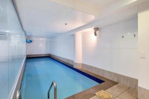a pool in a gym with a swimming pool at Metro Living Apt near Skytower and Parking in Auckland