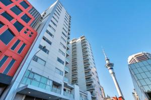 a tall building with the tv tower in the background at Metro Living Apt near Skytower and Parking in Auckland