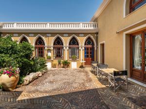 un patio de una casa con sillas y mesas en La Torretta Domus, en Quartu SantʼElena