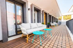 a balcony with a couch and two tables at ALTIDO Bairro Alto 2-BR Apartment with Large Terrace in Lisbon