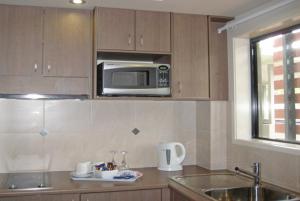 a kitchen with a sink and a microwave at Johnson Road Motel in Browns Plains