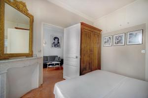 カンヌにあるAppartement Cannes Centreのベッドルーム(ベッド1台、鏡、暖炉付)