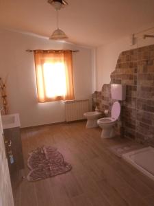łazienka z toaletą, umywalką i oknem w obiekcie B&B Marcello & Francesca w mieście Urbino