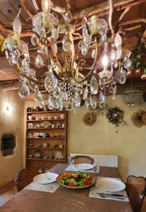 une salle à manger avec une table et un lustre dans l'établissement La chambre d'hôte du Petit Mazilloux, à Présailles