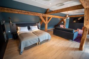 a bedroom with a bed and a couch at Hotell Bondeheimen in Oslo