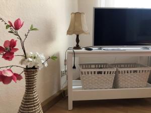 a living room with a tv and a vase with flowers at Ferienwohnung Buschbeck in Marienberg