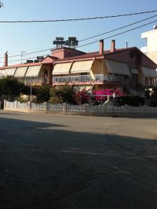 un bâtiment avec une clôture blanche en face d'une rue dans l'établissement Iliana, à Prévéza