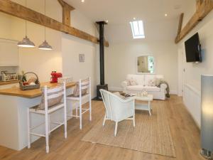 a living room with a table and chairs and a stove at March Hare in Ashbourne