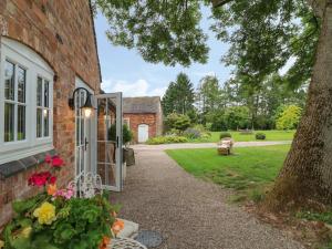 an open door to a brick house with a yard at Barn Owl in Ashbourne