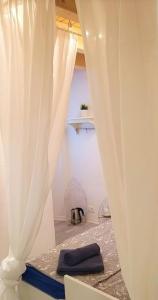 a room with a white curtain and a table at PiranArt Guest house in Piran