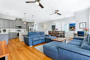 sala de estar con sofás azules y cocina en Hosteeva Amazing 4 BR Modern Condo with Balcony Near Frnch Quarter, en Nueva Orleans