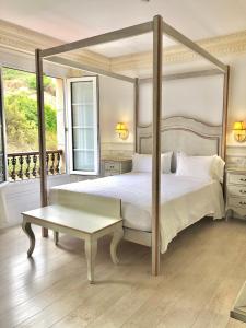 a bedroom with a canopy bed and a coffee table at Hotel Fonte do Fraile in Malpica