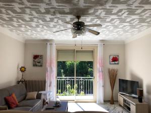 a living room with a ceiling fan and a couch at Jaures Home in Carmaux