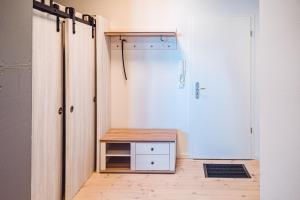 Zimmer mit einem Schrank mit einem Tisch und einer Tür in der Unterkunft Windrose in Barth