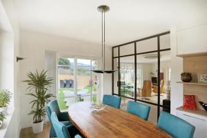 ein Esszimmer mit einem Holztisch und blauen Stühlen in der Unterkunft Homestay Villa Estrella - Costa Brava in Calella