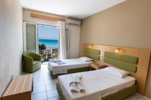a hotel room with two beds and a view of the ocean at Surf Hotel in Vasiliki