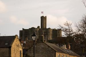 an old castle sitting on top of a city at Warkworth House Hotel in Warkworth