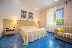 een slaapkamer met een bed, een bank en een raam bij Hotel Ipomea Club in Capo Vaticano