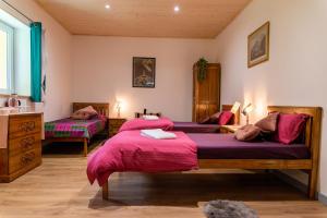 1 dormitorio con 2 camas y mantas rosas en Sanskriti, en Scionzier