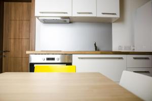 a kitchen with a wooden table and yellow chairs at Cresta Beach Studios in St. Julianʼs
