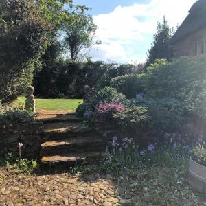 a garden with a stone path and flowers at Hunt House Quarters in Kilsby