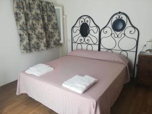 ein Schlafzimmer mit einem Bett mit zwei Handtüchern darauf in der Unterkunft Agricola casa cucina bottega in Cesena