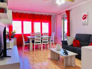 a living room with a table and red curtains at CENTRICO LABRADORES 15 in Peniscola